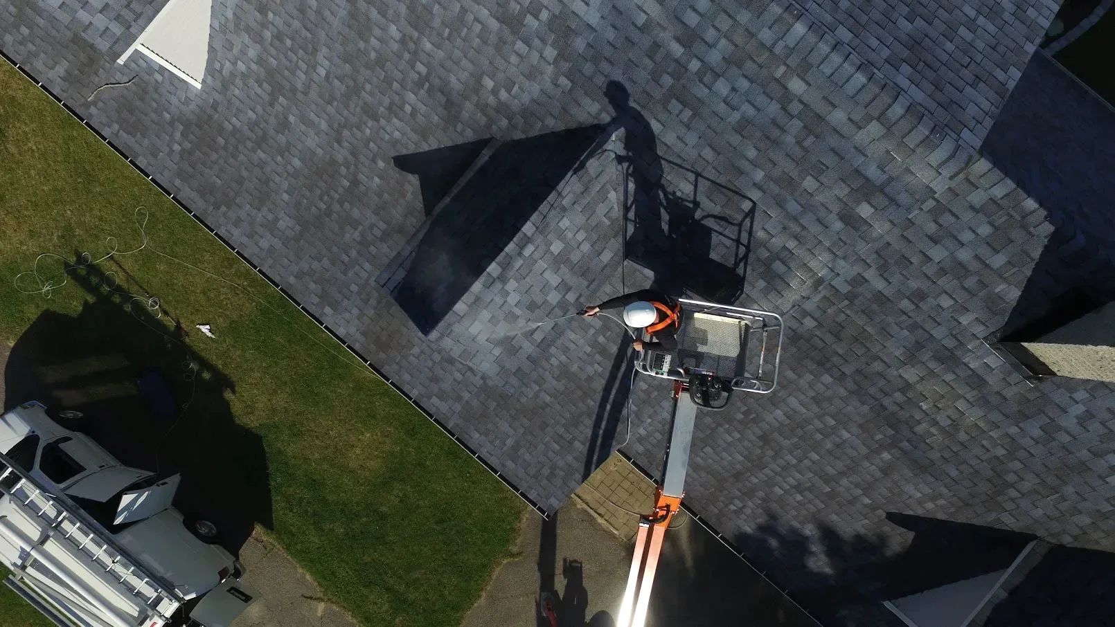 Roof gutter and downspout collecting loose asphalt-shingle granules after rainfall