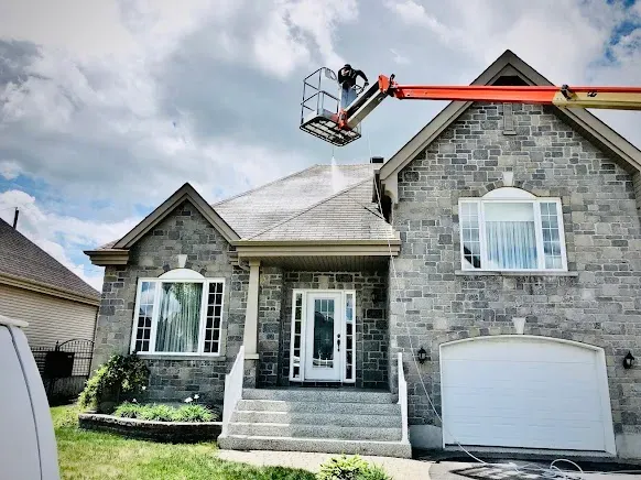 Professional technician applying a GoNano treatment to an asphalt-shingle roof